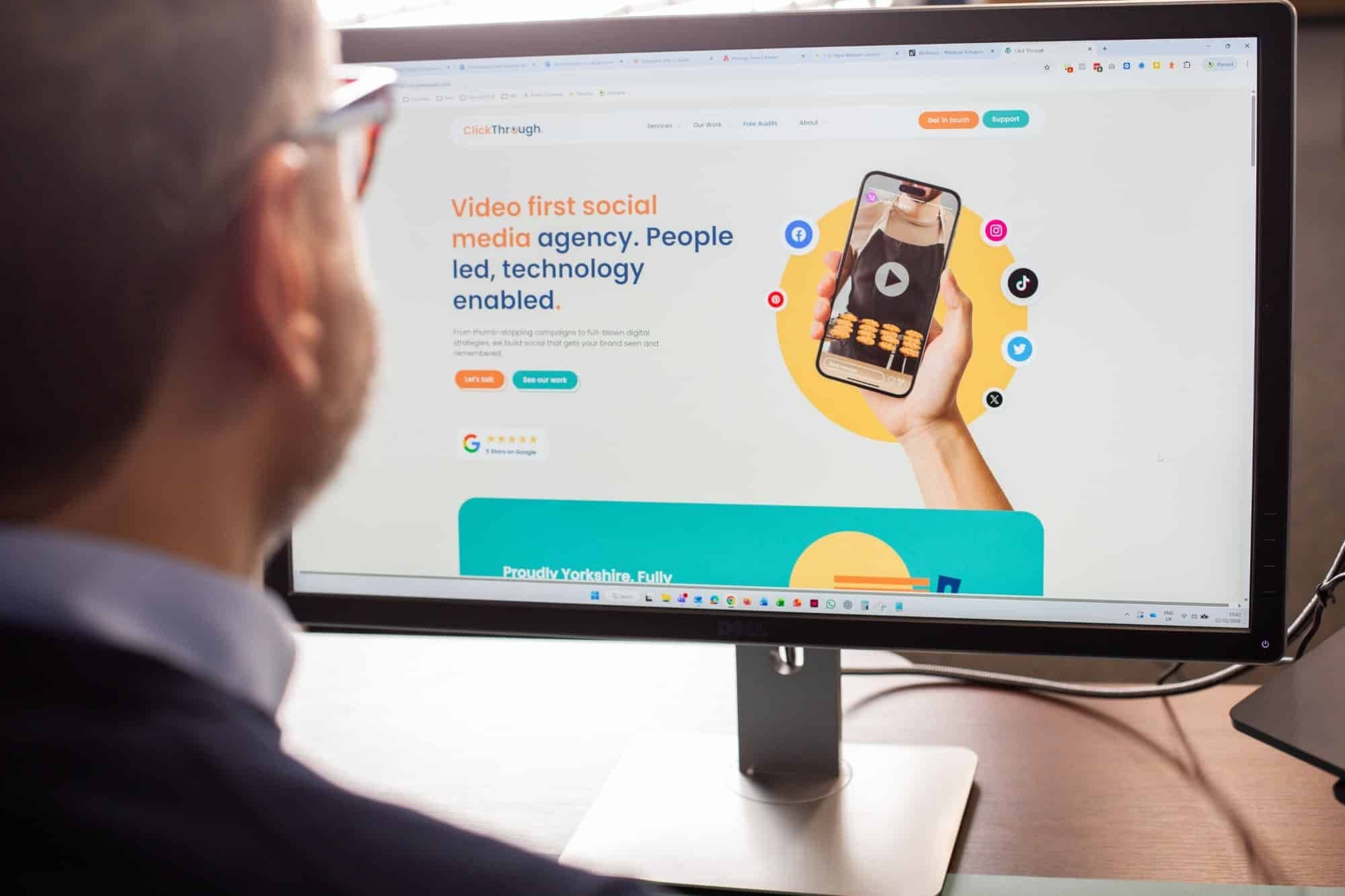 A man looking at a website on his monitor