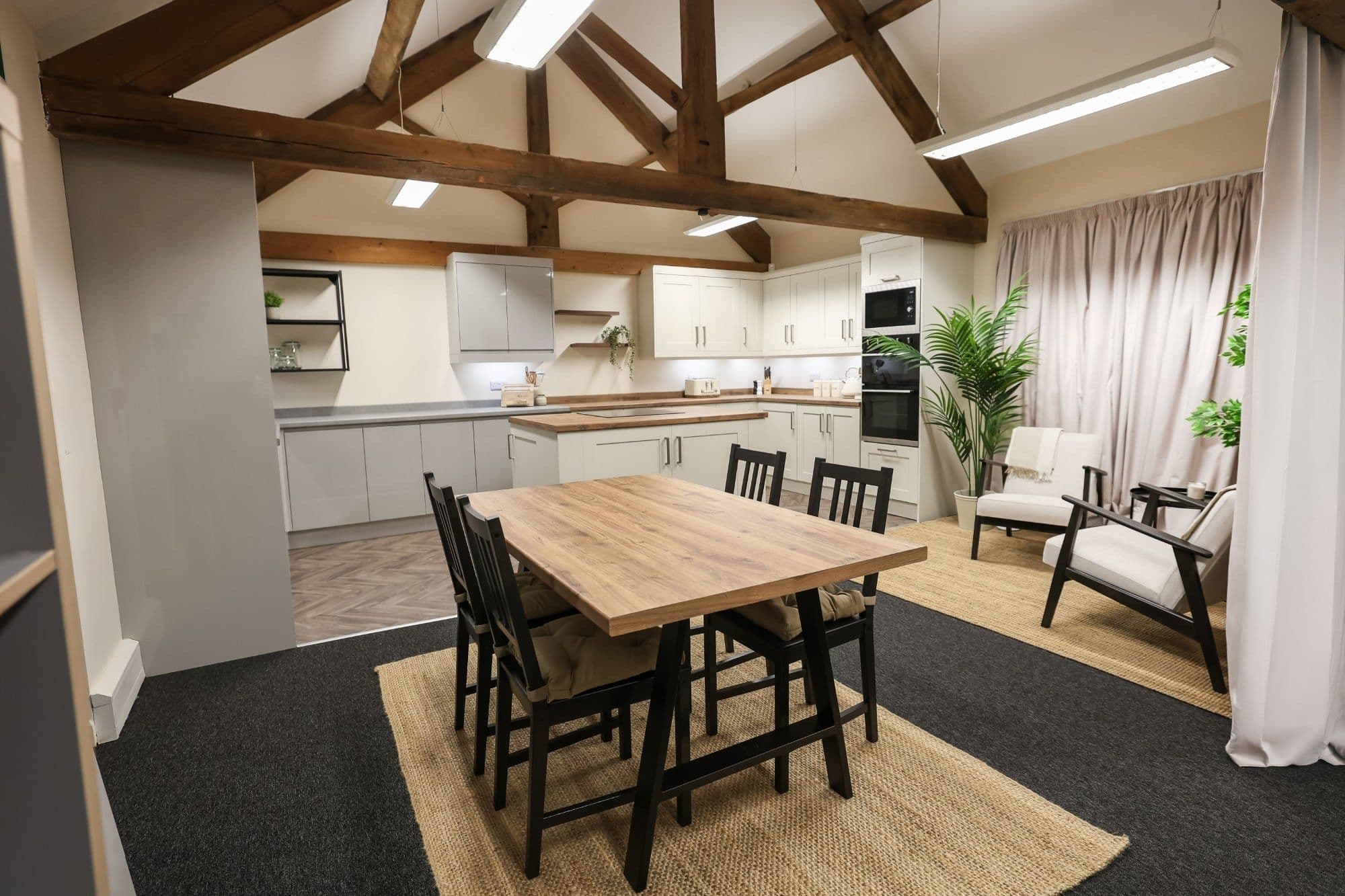 The studio's dining table and chairs, with the kitchen set behind
