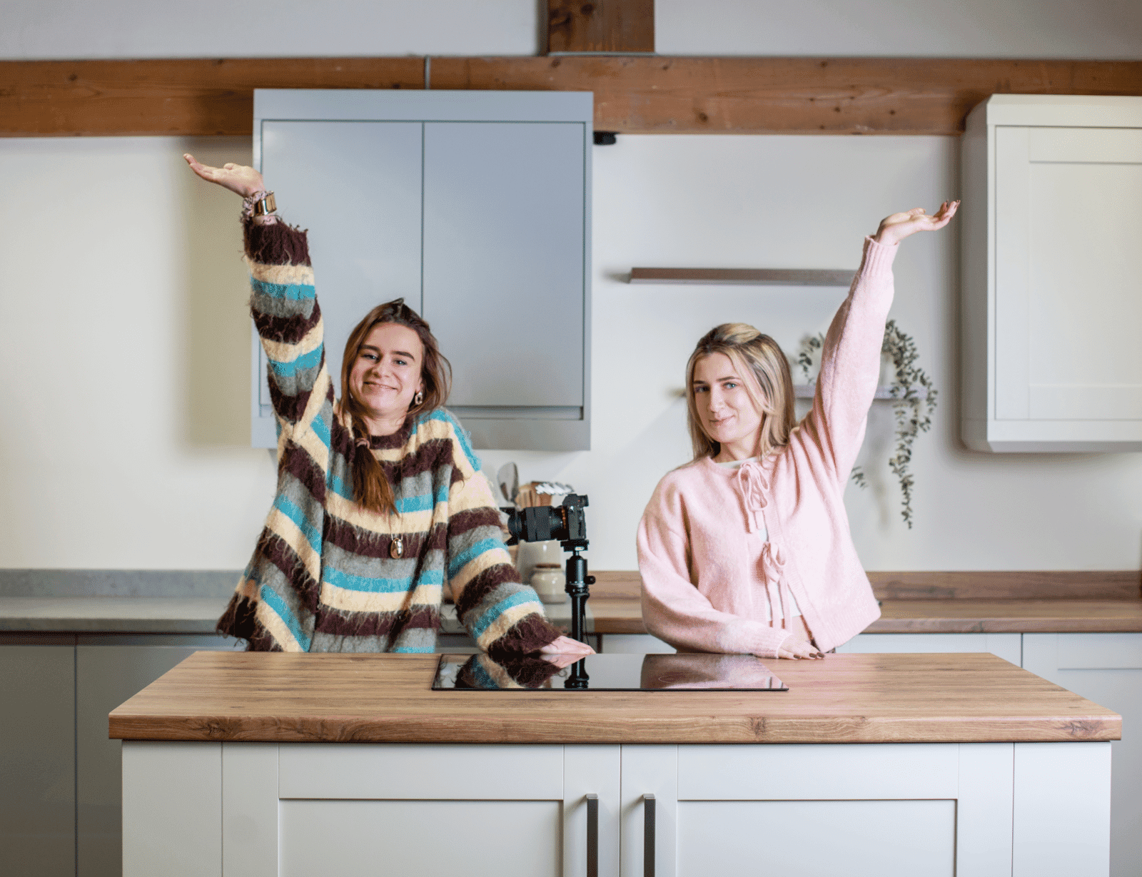 Two people raising their arms behind a kitchen island